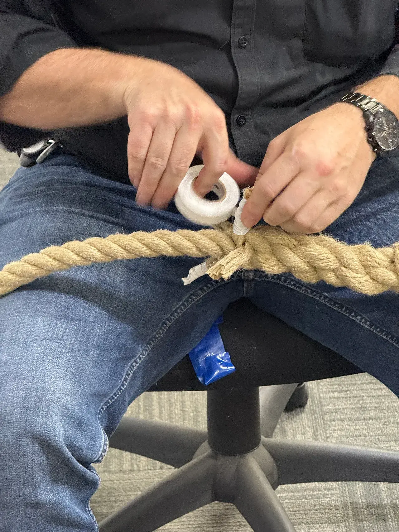 Hands whipping a rope end with twine to stop it fraying