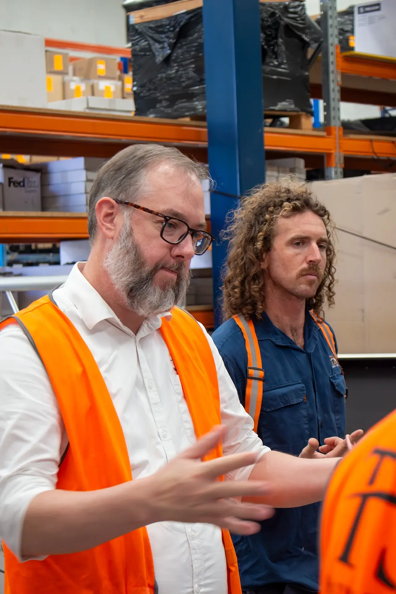 Two TSA staff talking through a training exercise on the warehouse floor