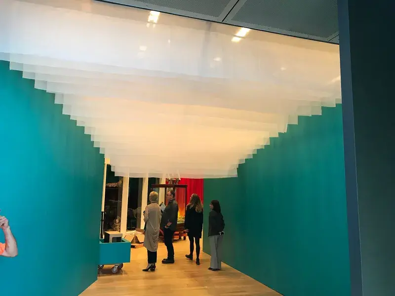 Scalloped voile entrance layered across a gallery foyer