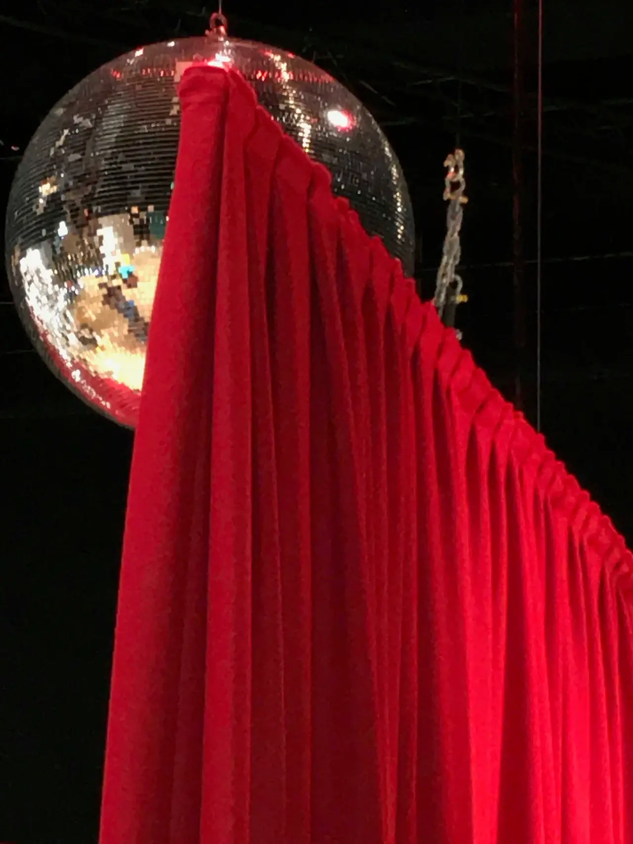 Red drape framing a mirrorball on stage