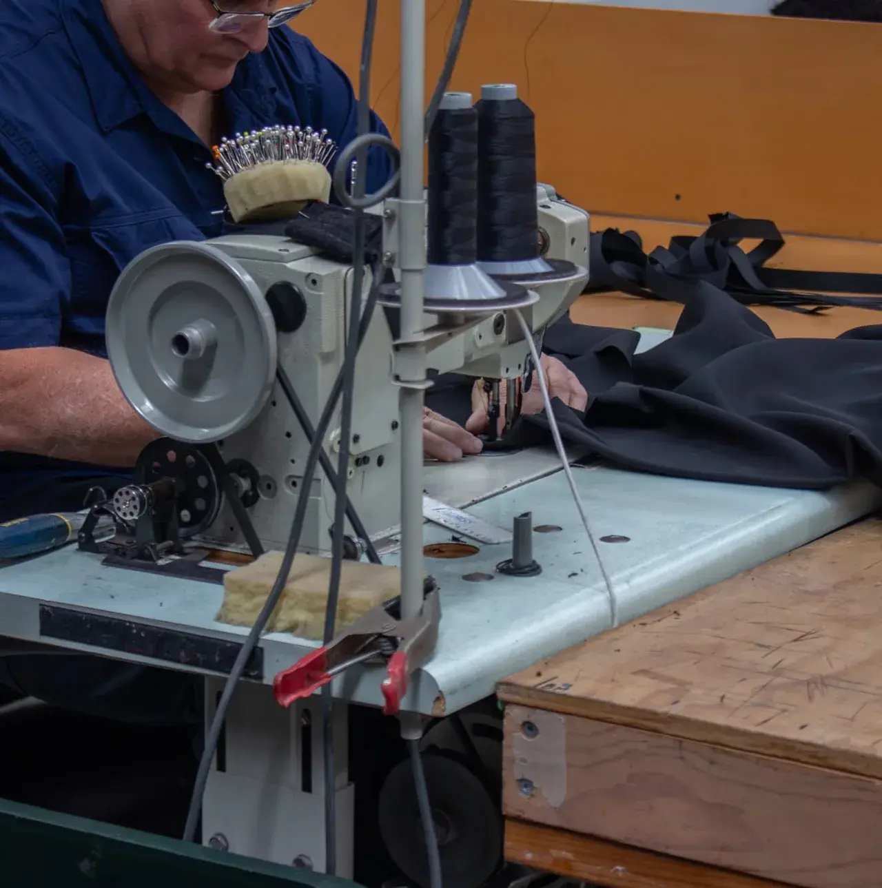 TSA in-house sewing line stitching a black FR-certified stage drape.