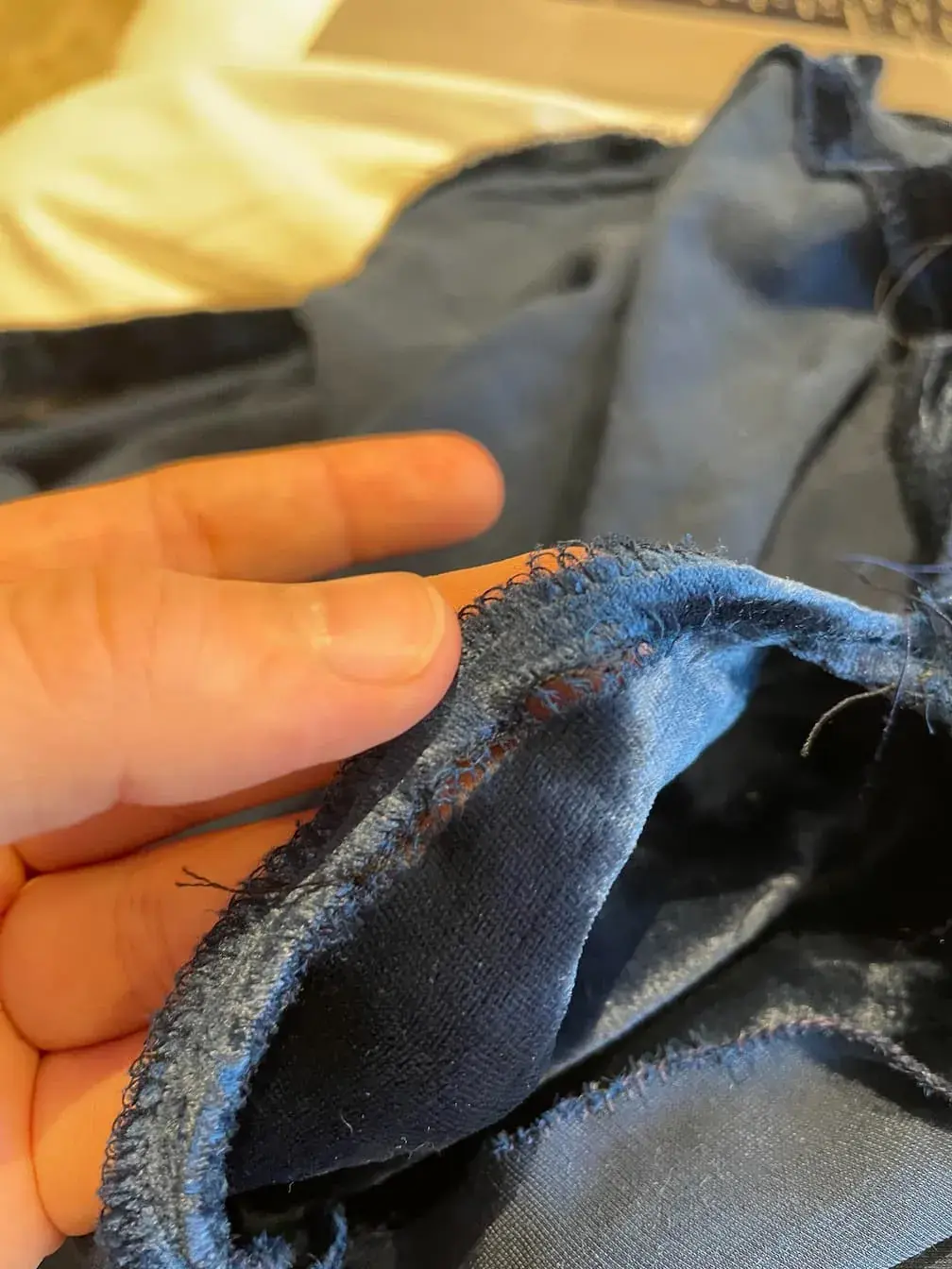 A stage drape on the workbench being repaired, with a seam re-stitched and the fabric handled flat.