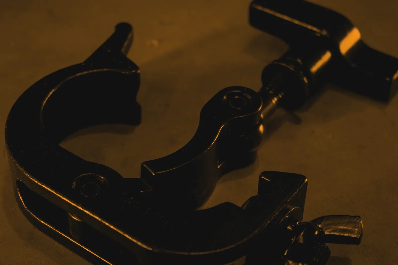 Quick coupler open on its hook jaw, T-handle tightener alongside