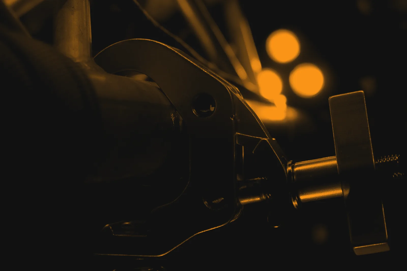 Self-lock coupler hooked onto a single tube with the T-handle set, stage lights behind