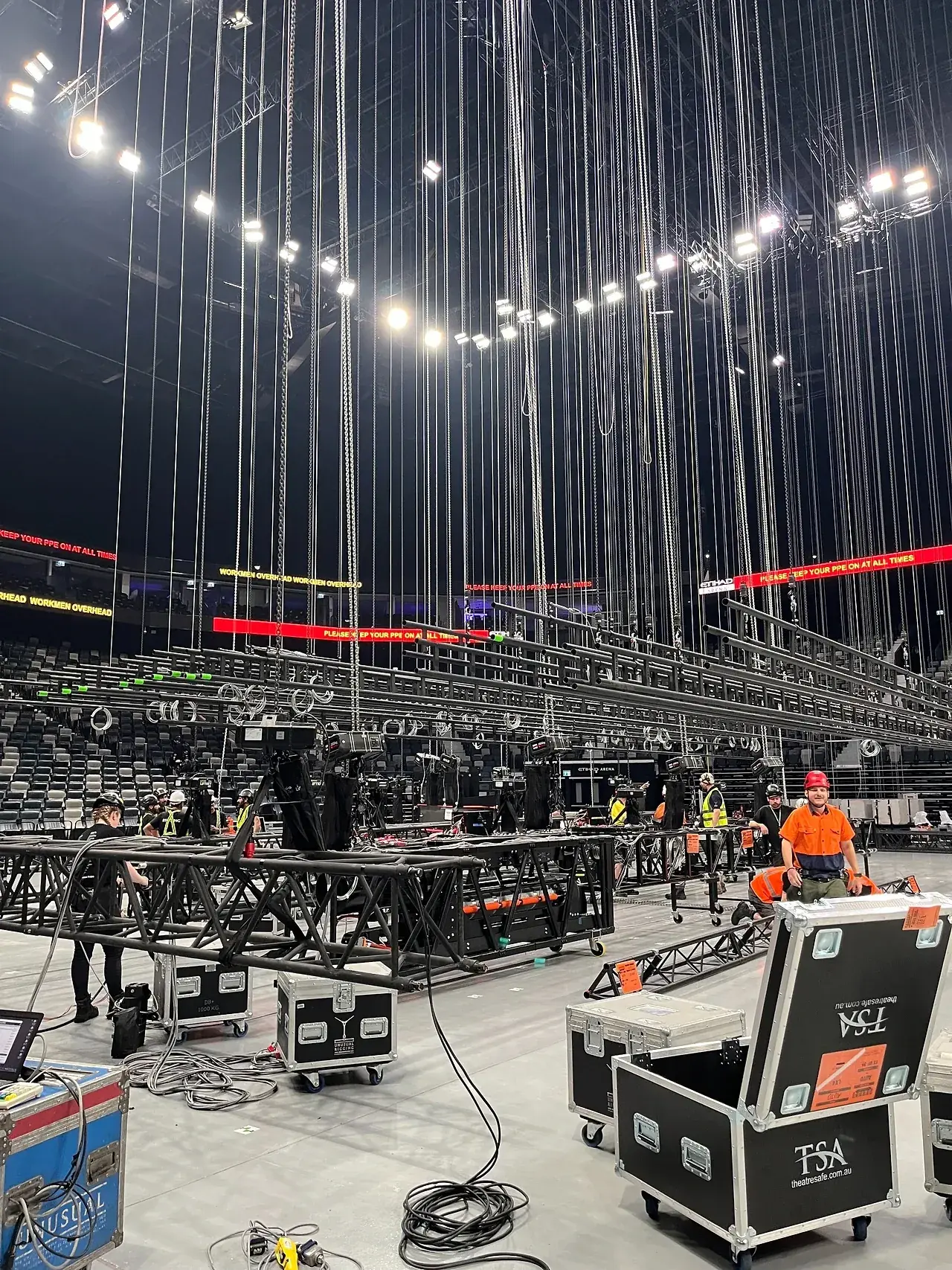 Chain hoists and rigging overhead during an arena load-in