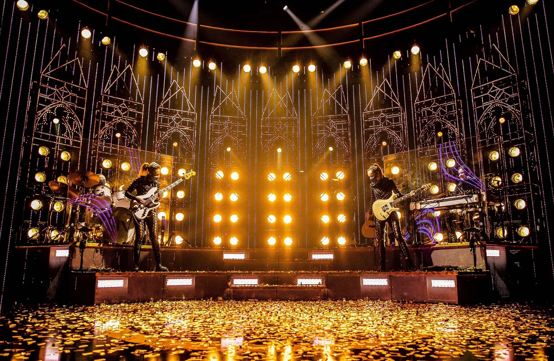 Wide full-stage view of SIX the Musical under gold concert lighting