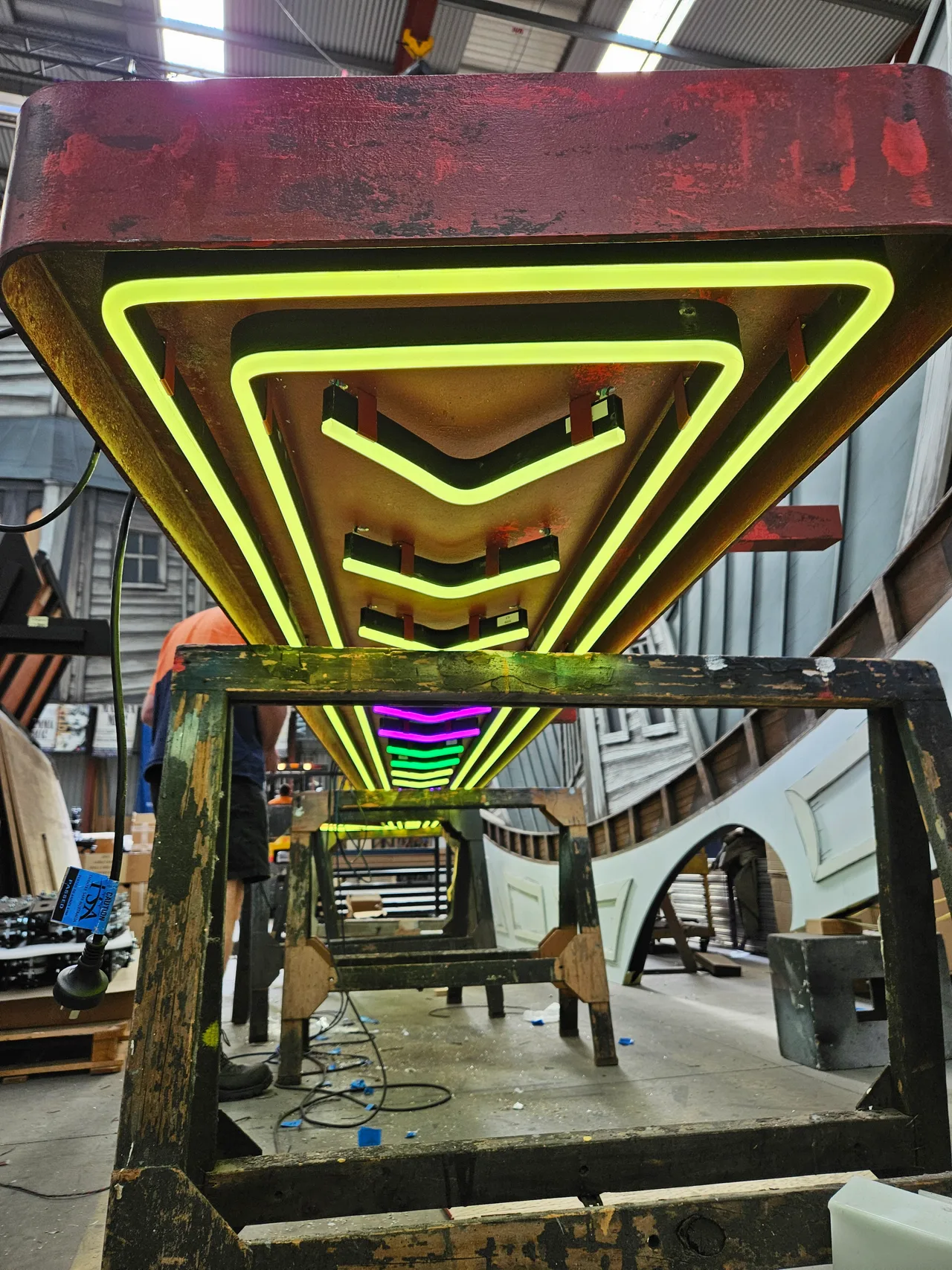 Nested neon chevron sign structure under construction in the workshop