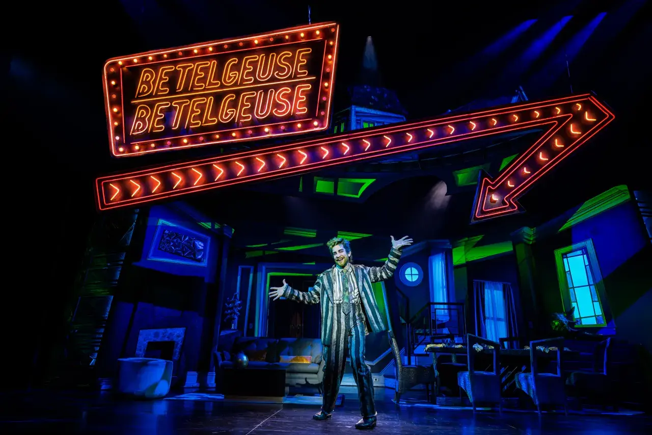 Beetlejuice The Musical on stage with the neon show sign, run to a cue