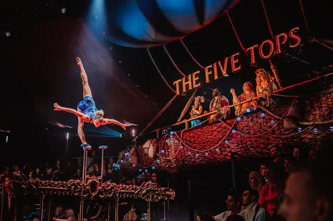 An aerial silk artist performing above the Come Alive arena