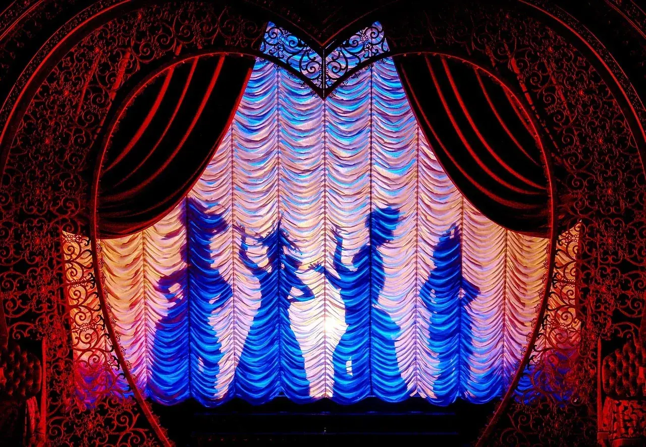 Moulin Rouge! The Musical full stage view, framed by Reveal-manufactured red drapes and festoon lighting. Photo: Michelle Grace Hunder.