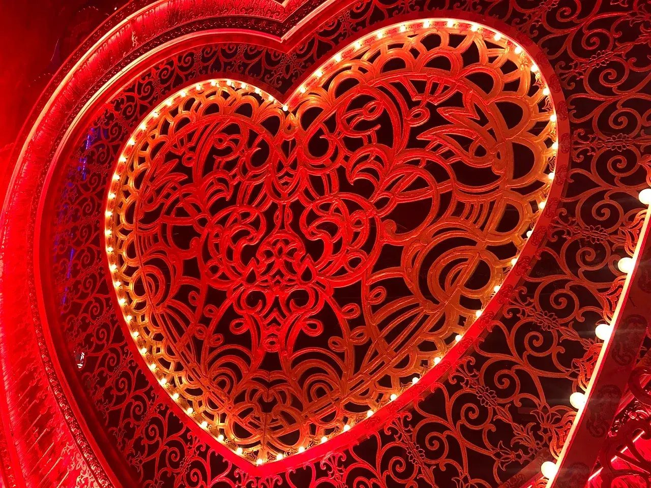 The finished filigree heart portal lit in red and gold on stage for Moulin Rouge! The Musical. Photo: TSA.