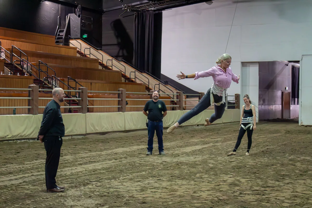 Performer in harness swinging on a flying line during training