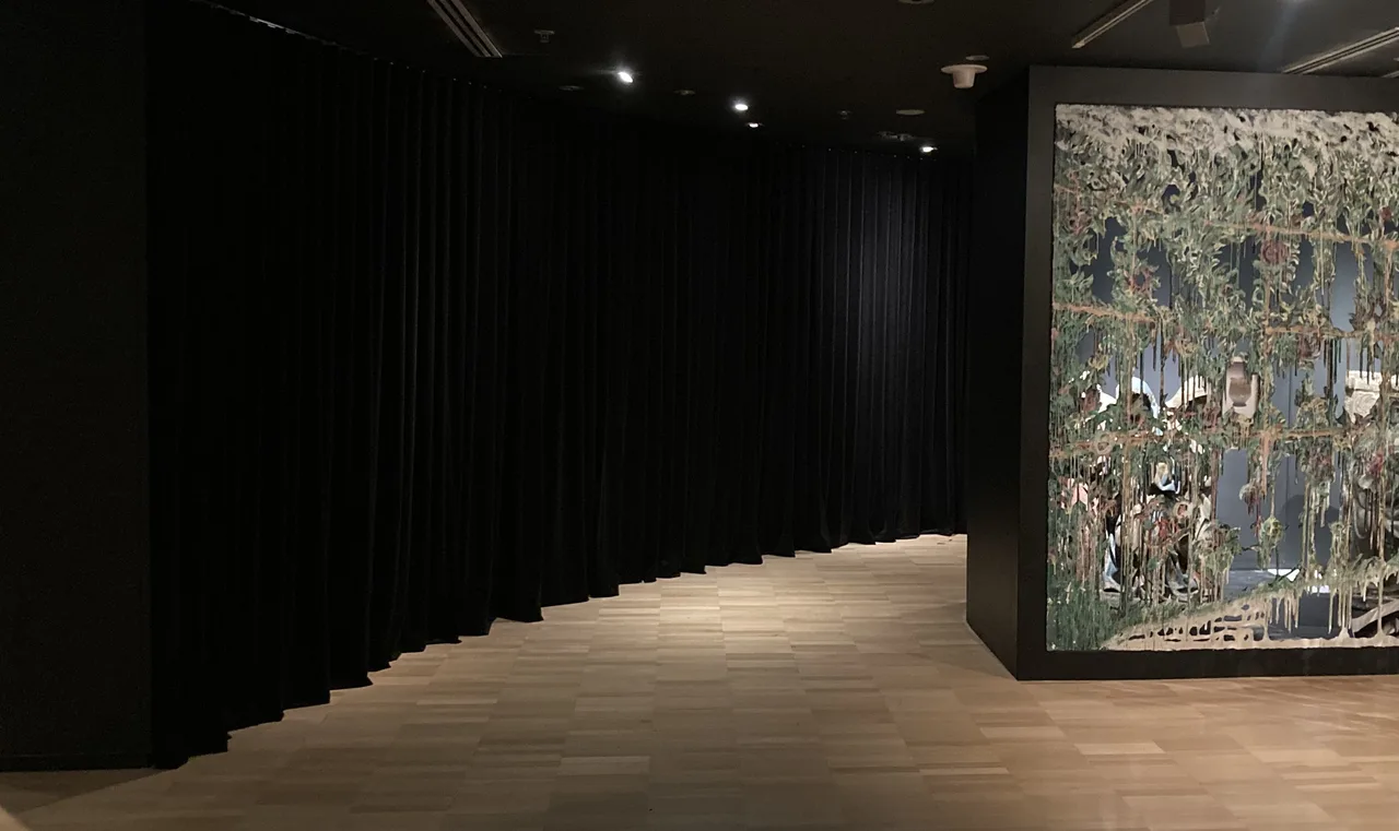 Black S-wave velvet drapes curving along a gallery corridor at the NGV Triennial