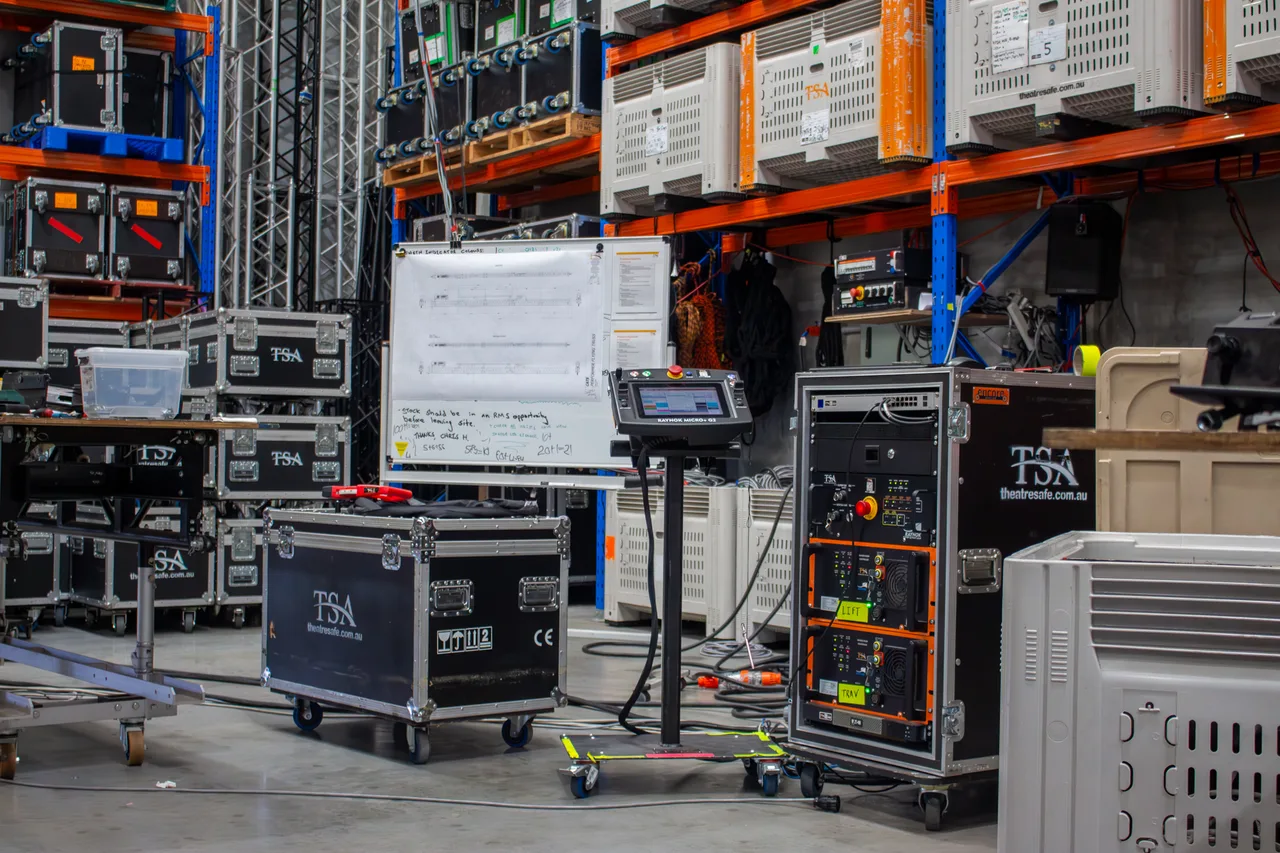 Warehouse setup for Cats performer flying with control console, hoist racks and road cases