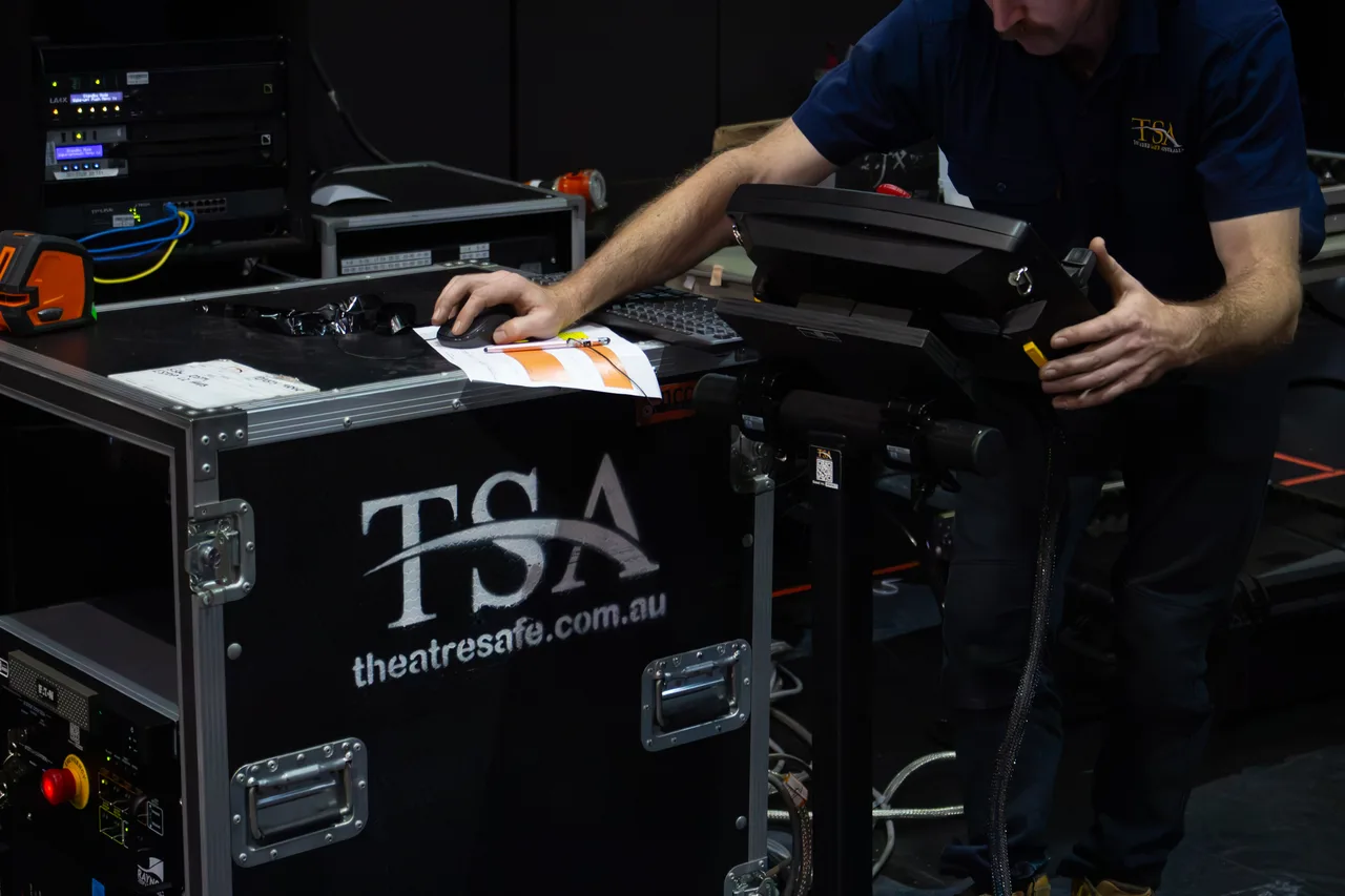 A technician setting up a performer flying control console backstage at The Star