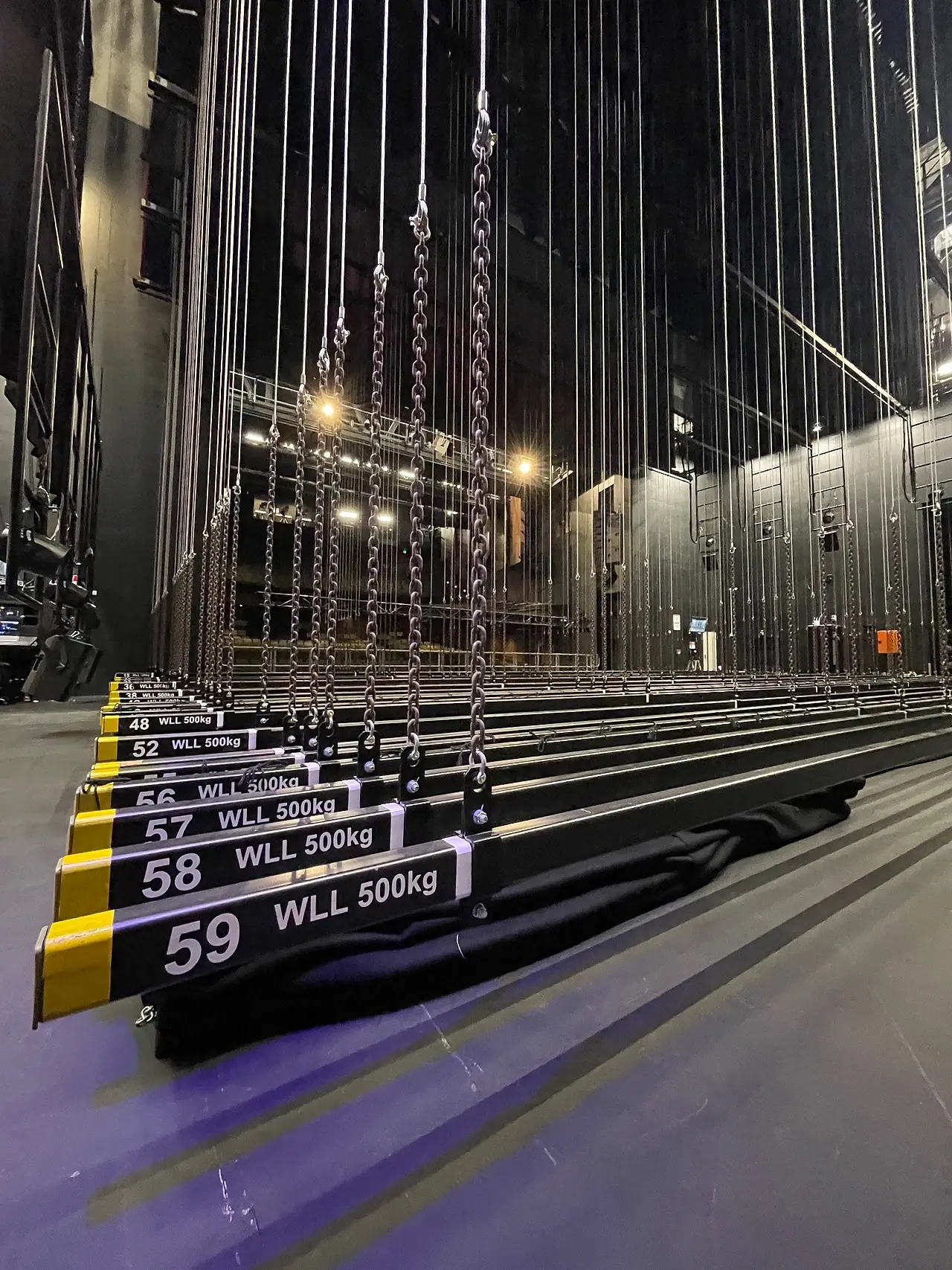 Numbered fly bars load-rated to 500kg WLL, chains receding up into a fly tower